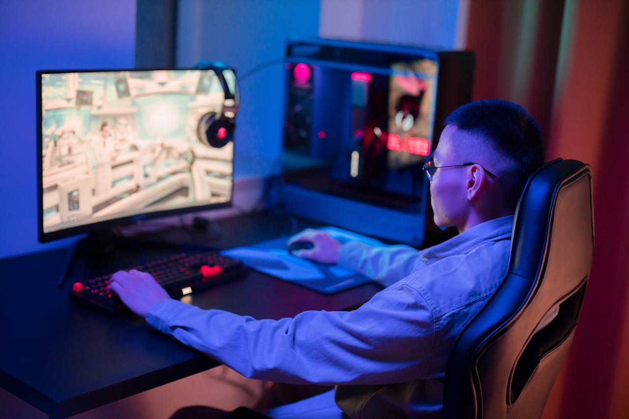 A young man intensely gaming on a computer at home, showcasing a modern gaming setup.